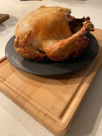 A turkey sitting on top of a black plate.